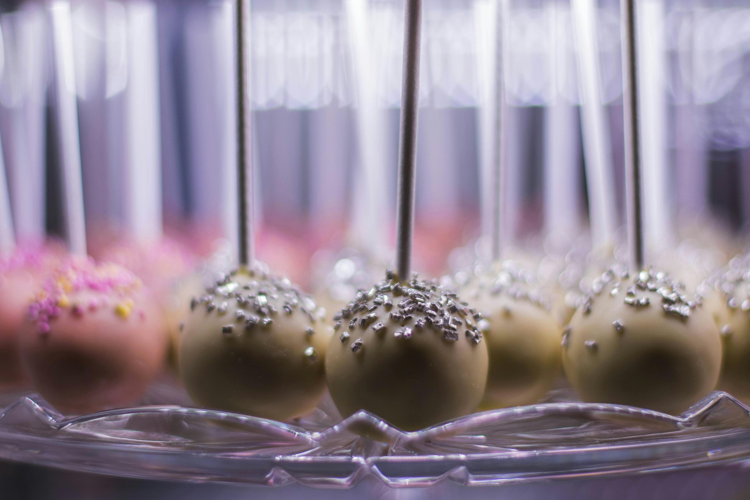 Delicious cake pops with sprinkles on display, perfect for dessert themes.